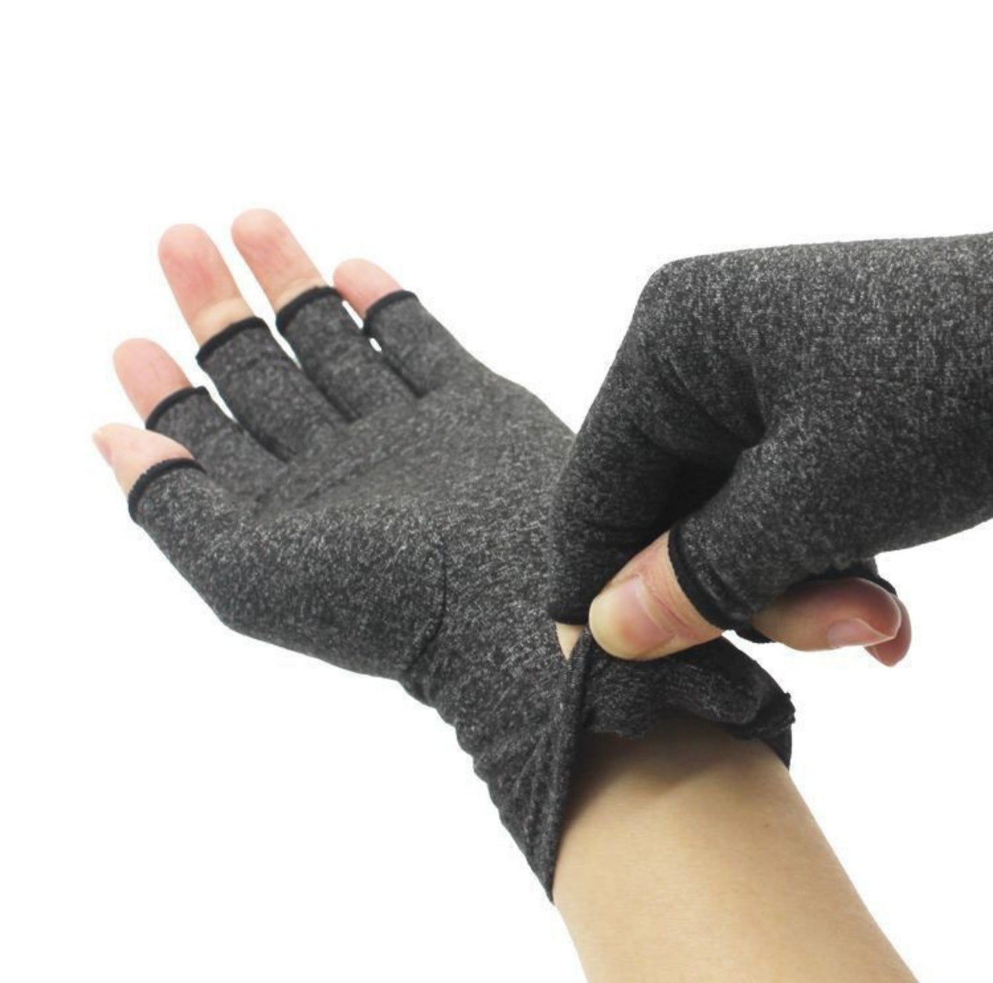 Grå kompressionshandskar utan fingertoppar som tas på och ger stöd vid artrit och stelhet i händerna.
