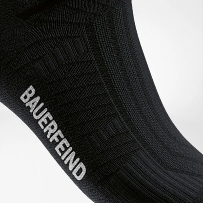 Närbild på Arch Support Zone och Bauerfeind-logga, svart strumpa
