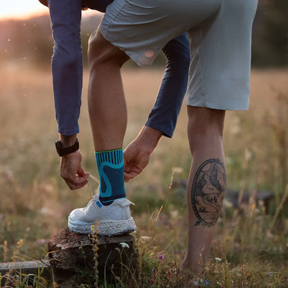 Person knyter skon med Sports Achilles Support på foten utomhus