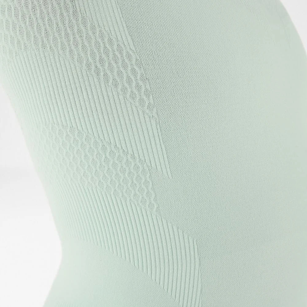 Närbild på stickningen med 3D Power Dots på den turkosa tröjan