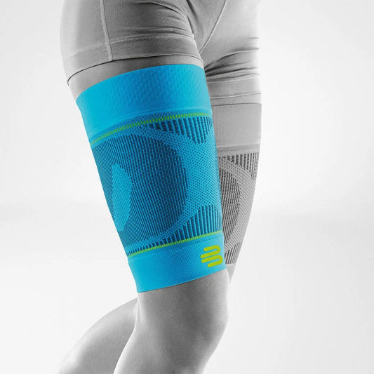 Bauerfeind Sports Compression Thigh Sleeve i rivera (ljusblå) på låret, vit bakgrund