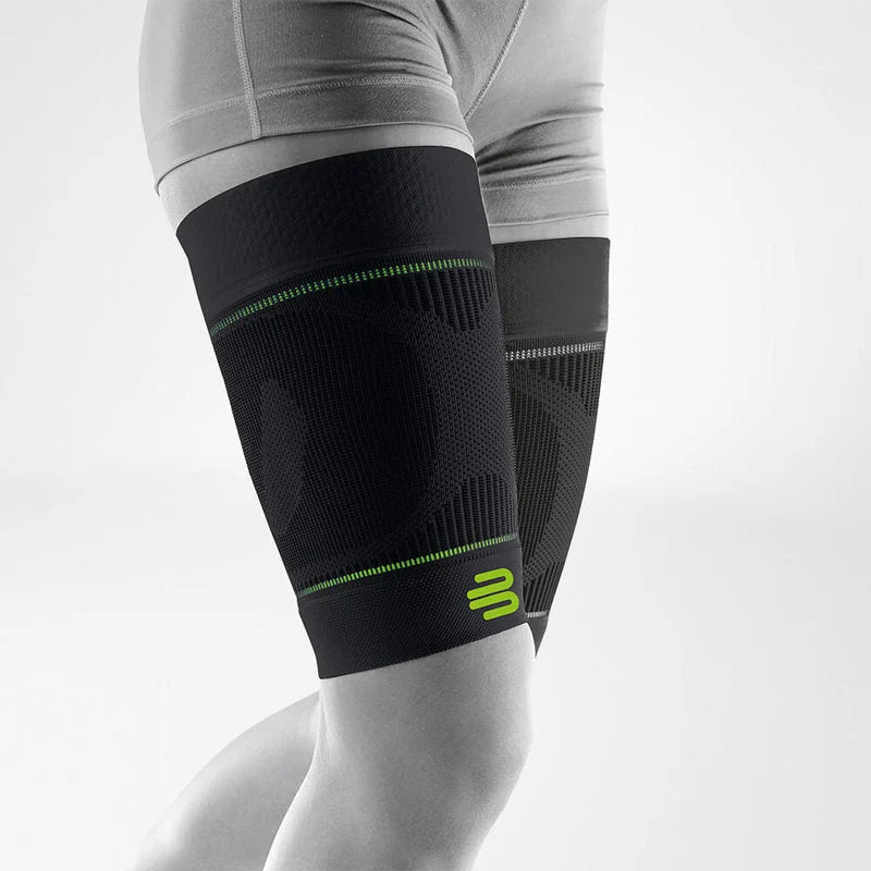Bauerfeind Sports Compression Thigh Sleeve i svart på låret, vit bakgrund