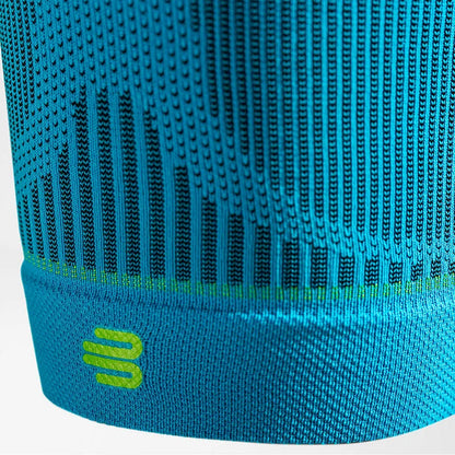 Närbild på nederkanten med Bauerfeind-logotyp på en thigh sleeve i rivera