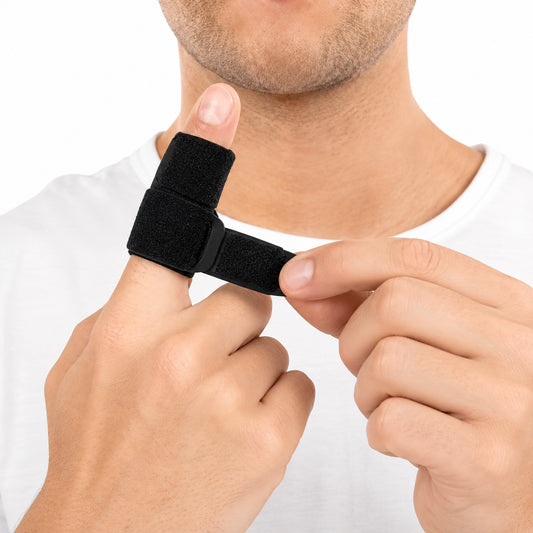 Man justerar ett svart fingerstöd med lätt kompression och anpassningsbar passform runt tummen.