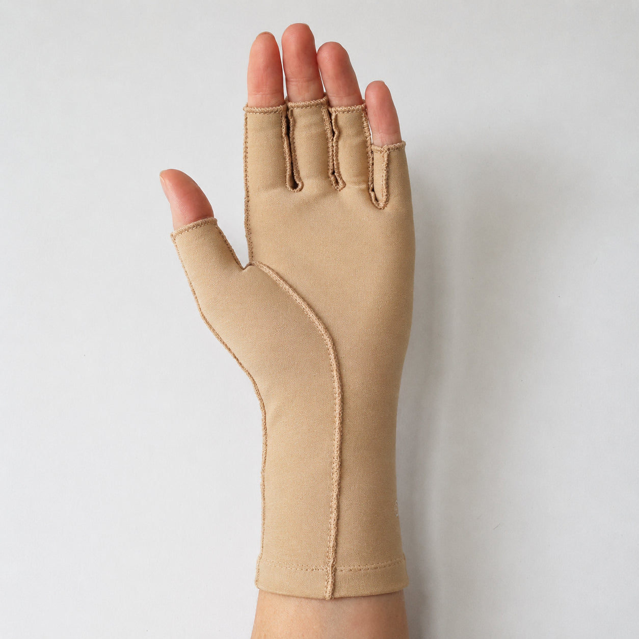 Medicinsk kompressionshandske för hand och handled med öppen fingertoppsdesign och bekväm passform.