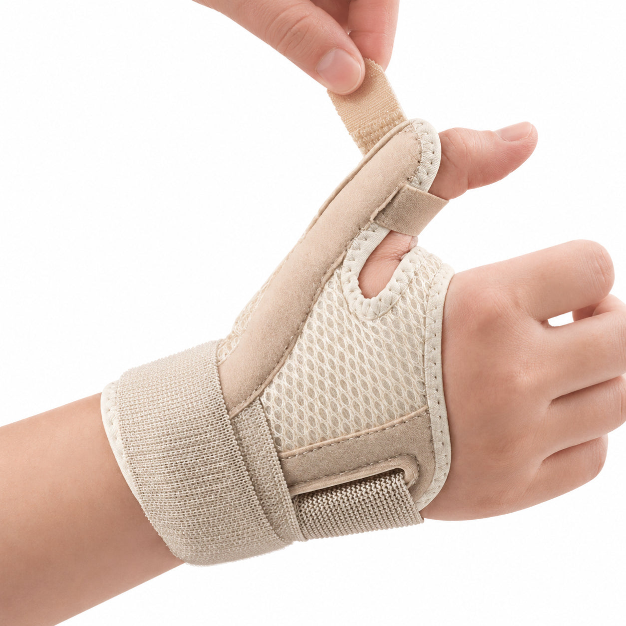 Tumme-stödsskena i beige meshmaterial med justerbara kardborreband som stabiliserar tumme och handled. Produktbild på hand som visar hur stödet appliceras.