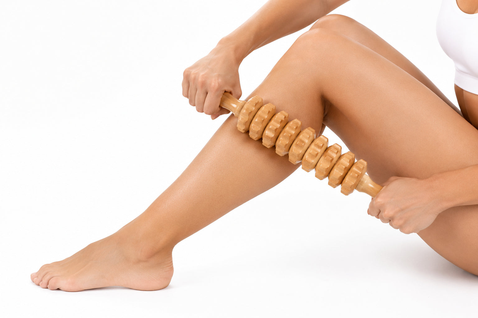 Person som masserar benet med en manuell massagerulle